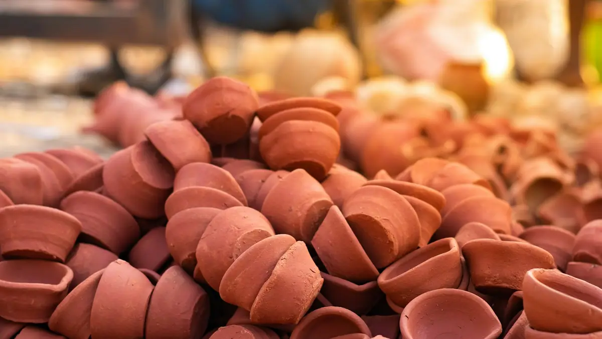 A large pile of plain clay diyas for sale at a market before Diwali