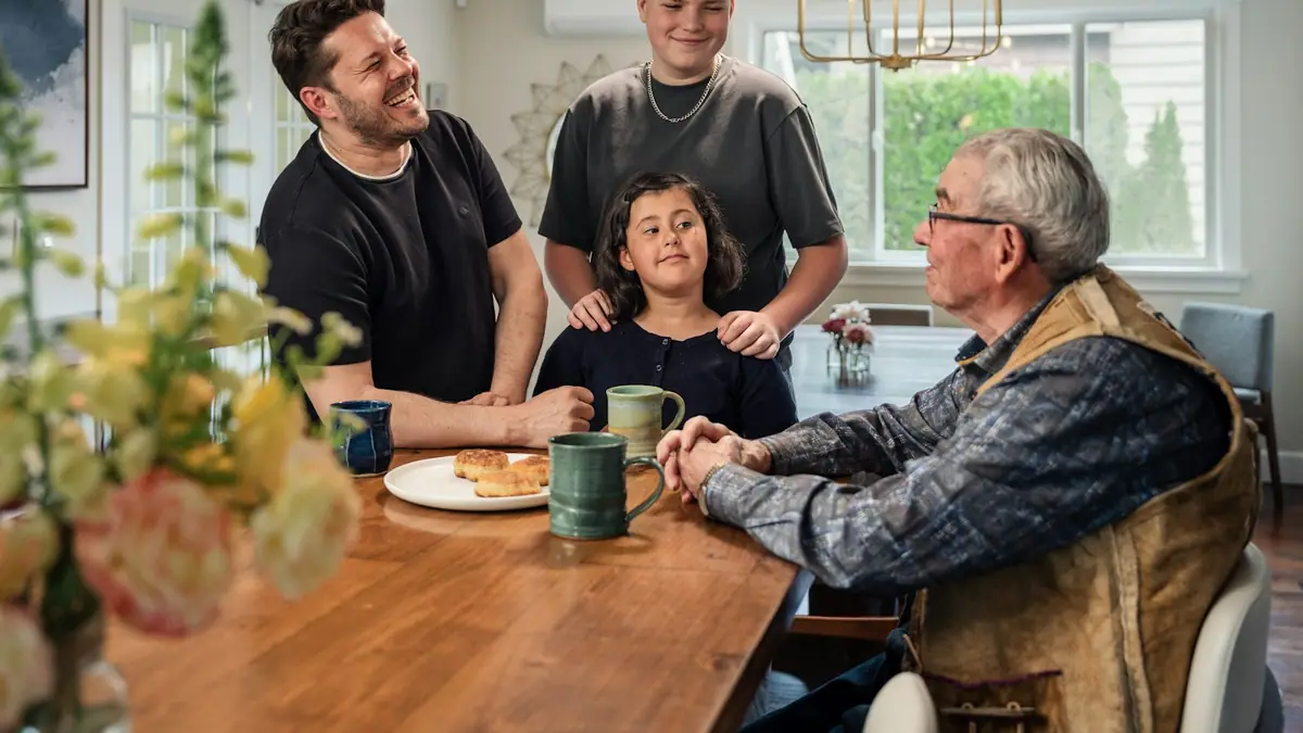 Three generations of a family gathered around a dining table