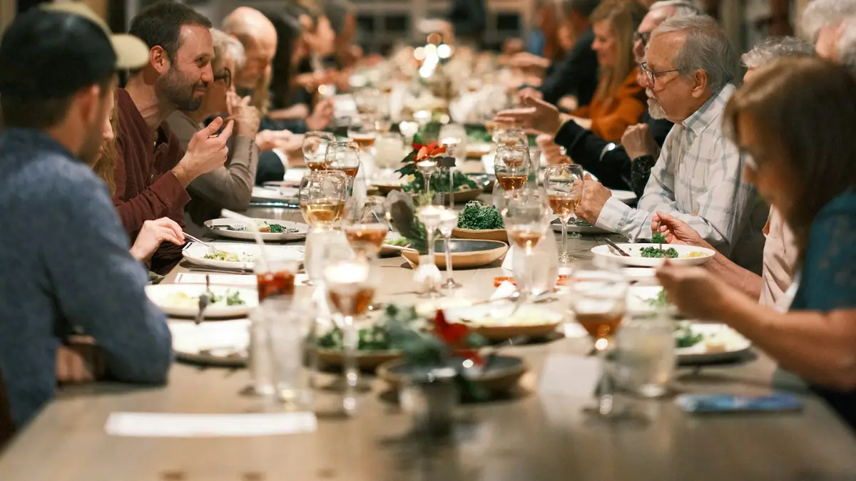 A large family gathered around a long dinner table