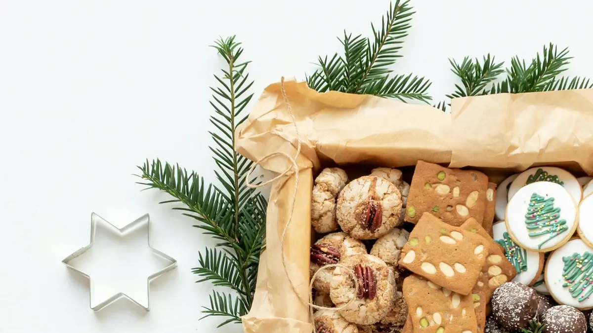 A gift box of homemade holiday cookies with pine branches