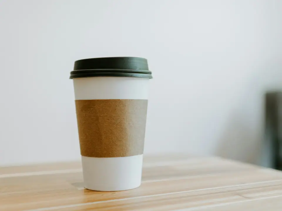 A takeaway coffee cup on a wooden table
