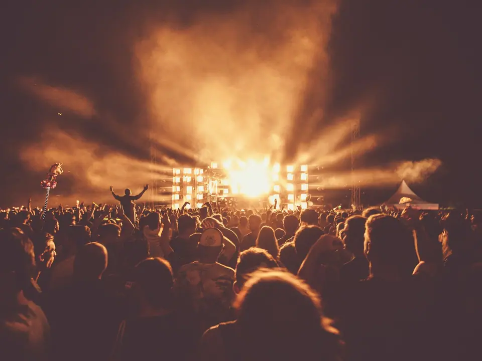 A crowd watching a concert under bright stage lights