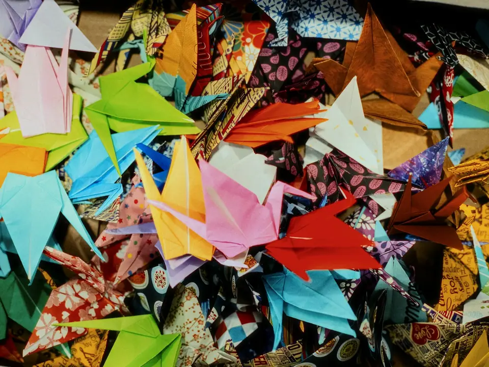 A pile of colorful folded paper cranes