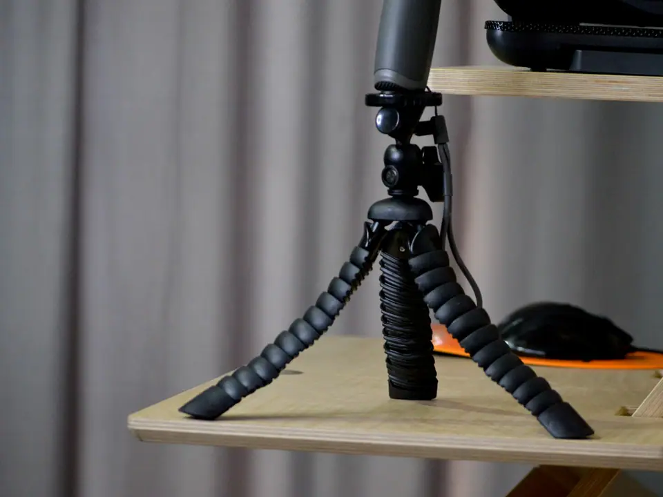 A small flexible tripod on a wooden shelf