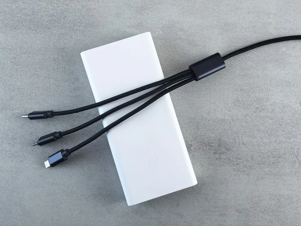 A white portable charger with three charging cables
