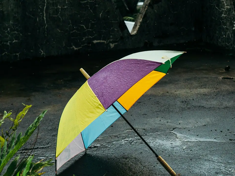 A colorful umbrella on wet ground in the rain