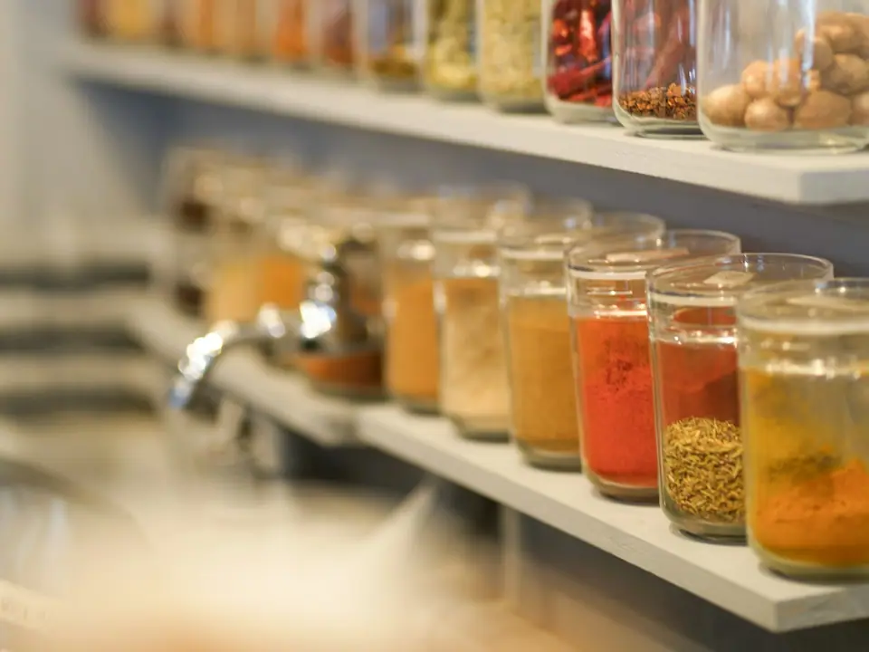 A row of glass jars filled with colorful spices